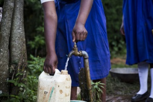 A school child fills a container with water from the community water tap
